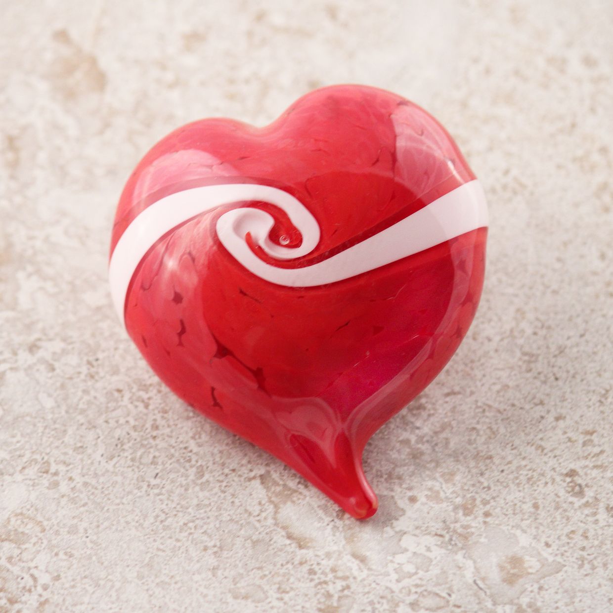 Heart-Right-Pointing-Sized A red heart with a ribbon of white moving from one side to the other with a twist in its center, denoting how two lives come together as one in the heart.